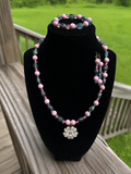 Pink and smoky-tone handmade necklace bracelet and earring set with flower detail.