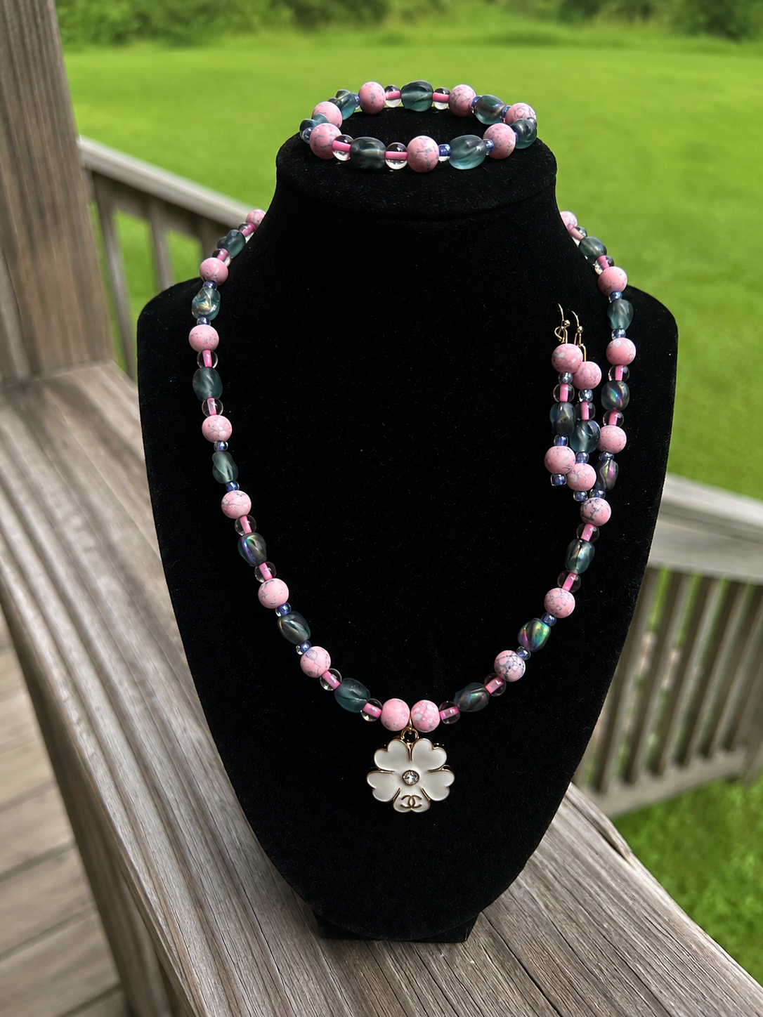 Pink and smoky-tone handmade necklace bracelet and earring set with flower detail.