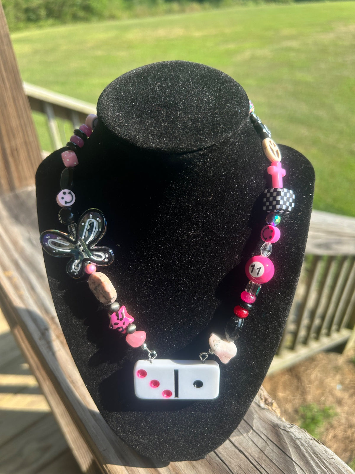Pink and black handmade statement necklace with domino-style focal and butterfly detail.
