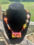 Orange domino-style handmade eclectic statement necklace with colorful mixed beads.
