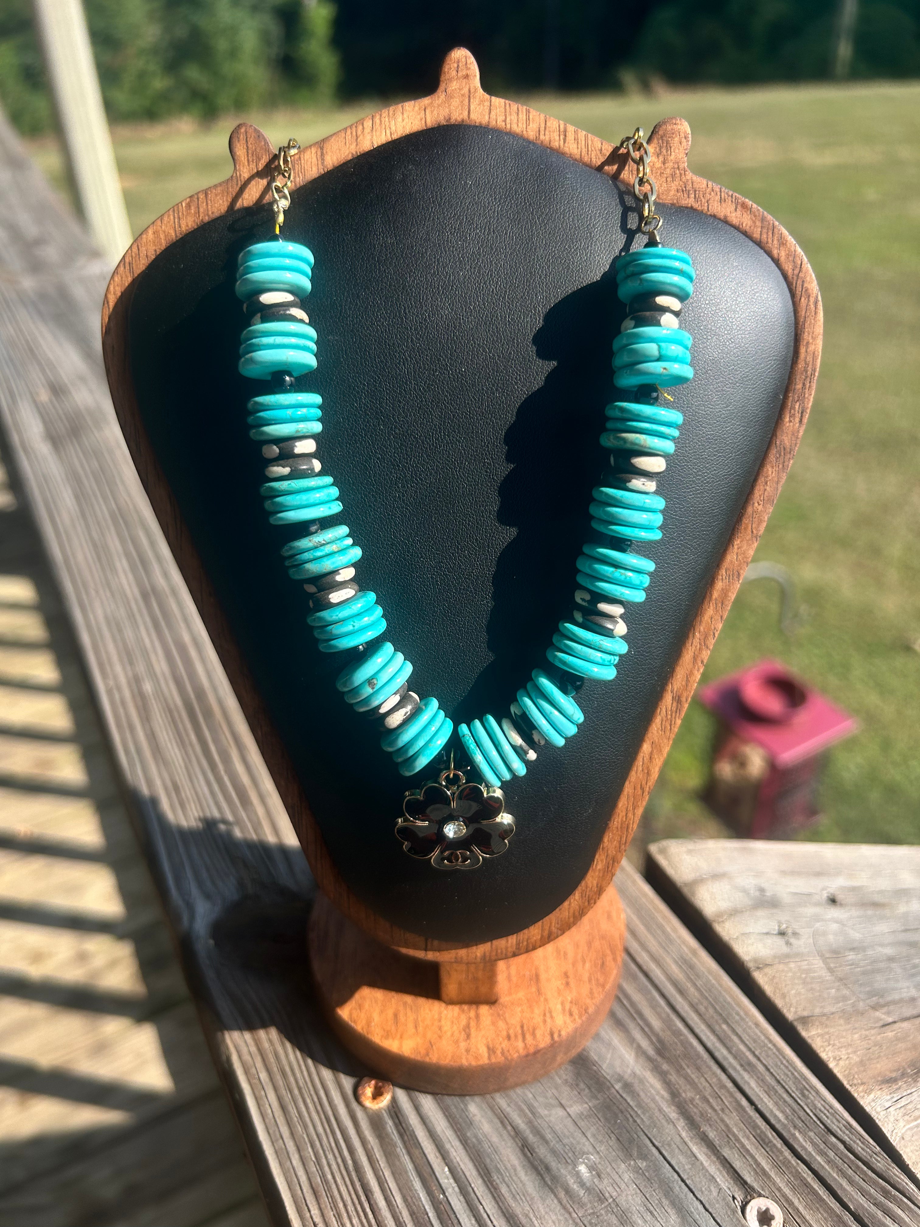 Turquoise-color black-and-white handmade statement necklace with floral focal.