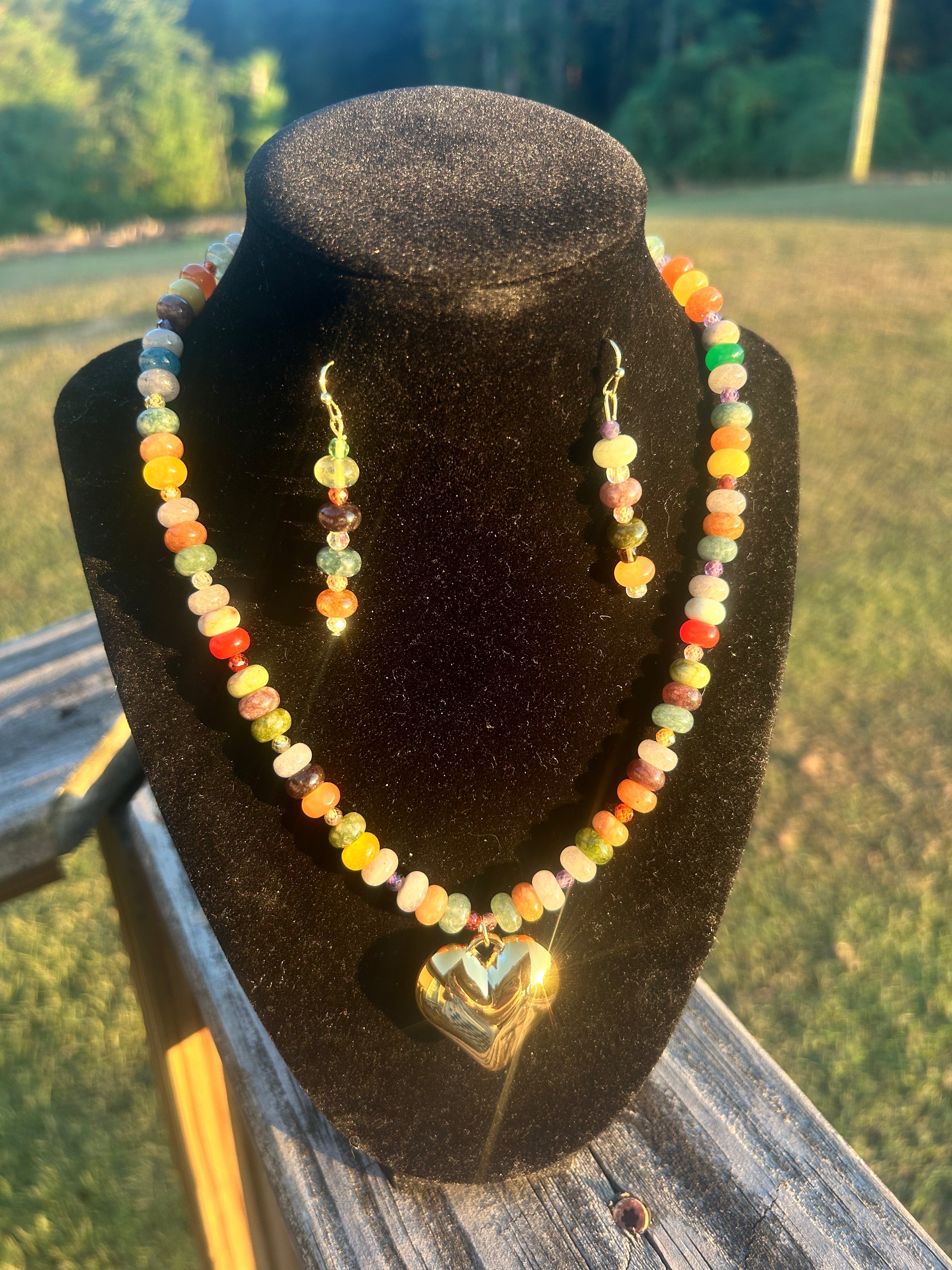 Colorful handmade beaded necklace and matching earrings with golden heart focal.