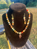 Multicolor western-boho beaded necklace and matching earrings with geometric pendant.