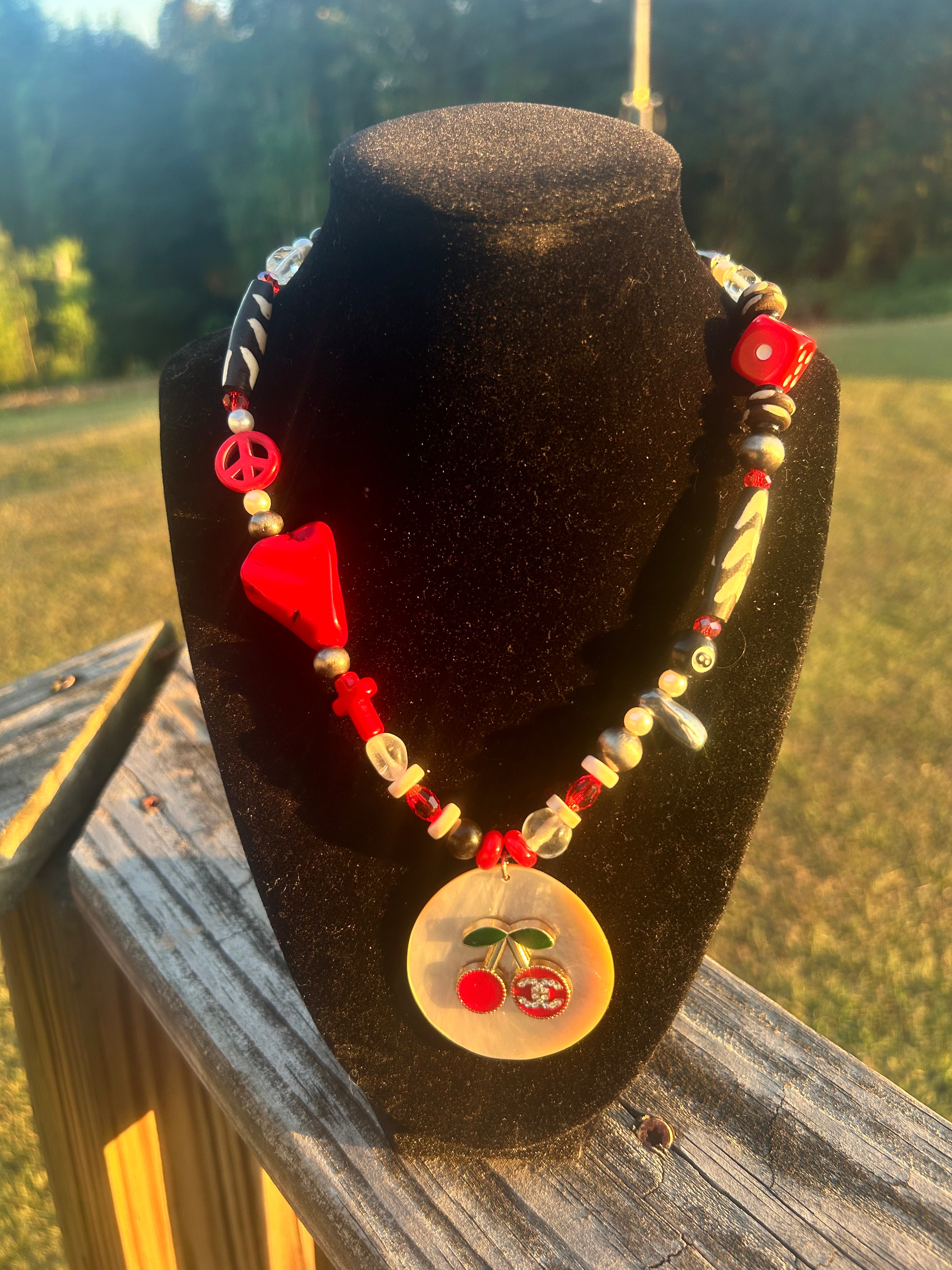 Handmade red, black and white eclectic statement necklace with mixed beads, peace sign accent and cherry focal pendant.